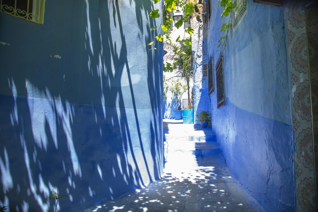A bright alley in the blue city of Chefchaouen, Morocco, showcasing vibrant architecture.