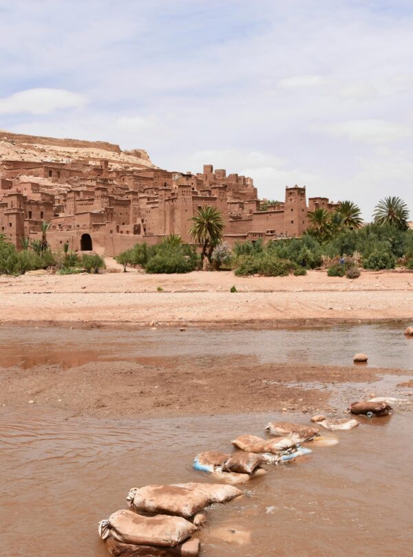 View of Aït Benhaddou, a historic ksar in Morocco, with desert surroundings.
